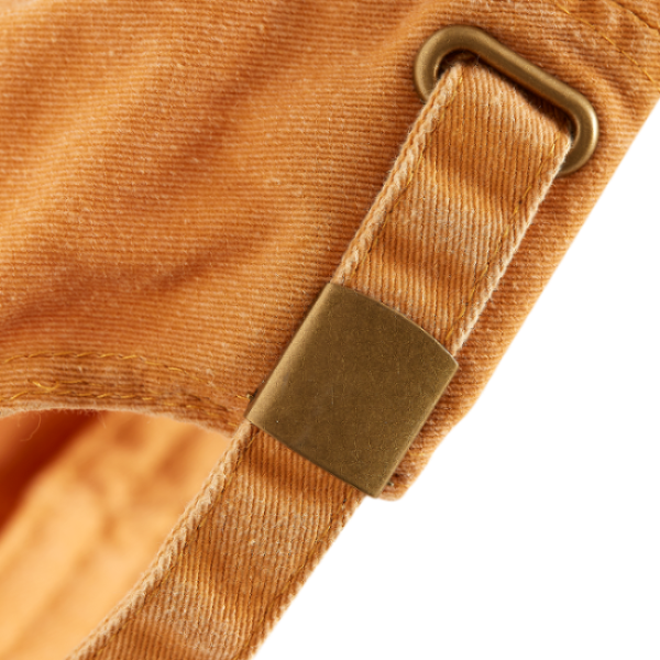 Skateovation dad cap in the colour mustard (vintage orange). Close-up of the adjustable strap with brass-effect buckle.
