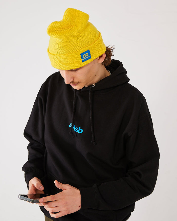 skater, looking at his mobile, wearing a yellow SO skateovation cuffed beanie and a black 4Msb hoodie.
