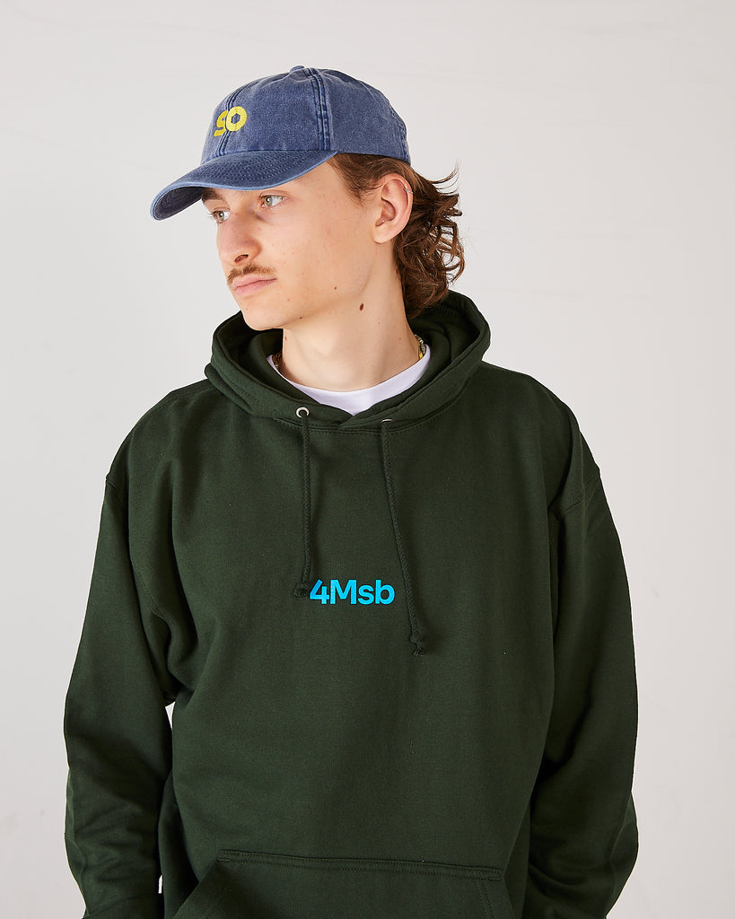 skater wearing skateovation so dad cap in vintage denim and a 4Msb hoodie dala horse in forest green.