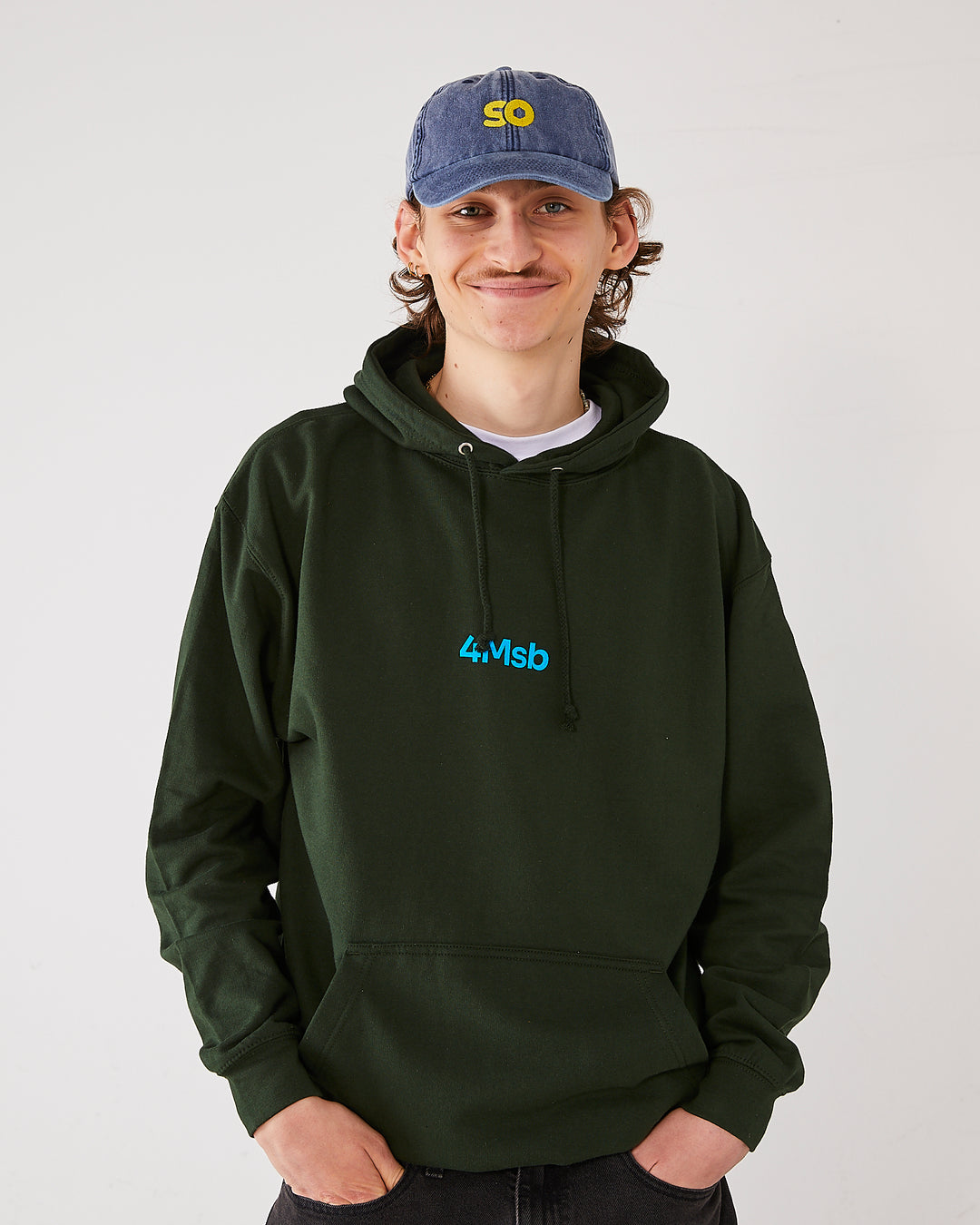 skater wearing skateovation so dad cap in vintage denim and a 4Msb hoodie dala horse in forest green.